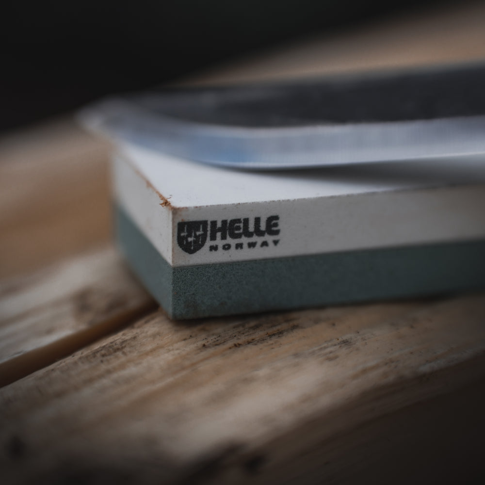 Helle Small Sharpening Stone with Leather Sheath Closeup with Knife Blade